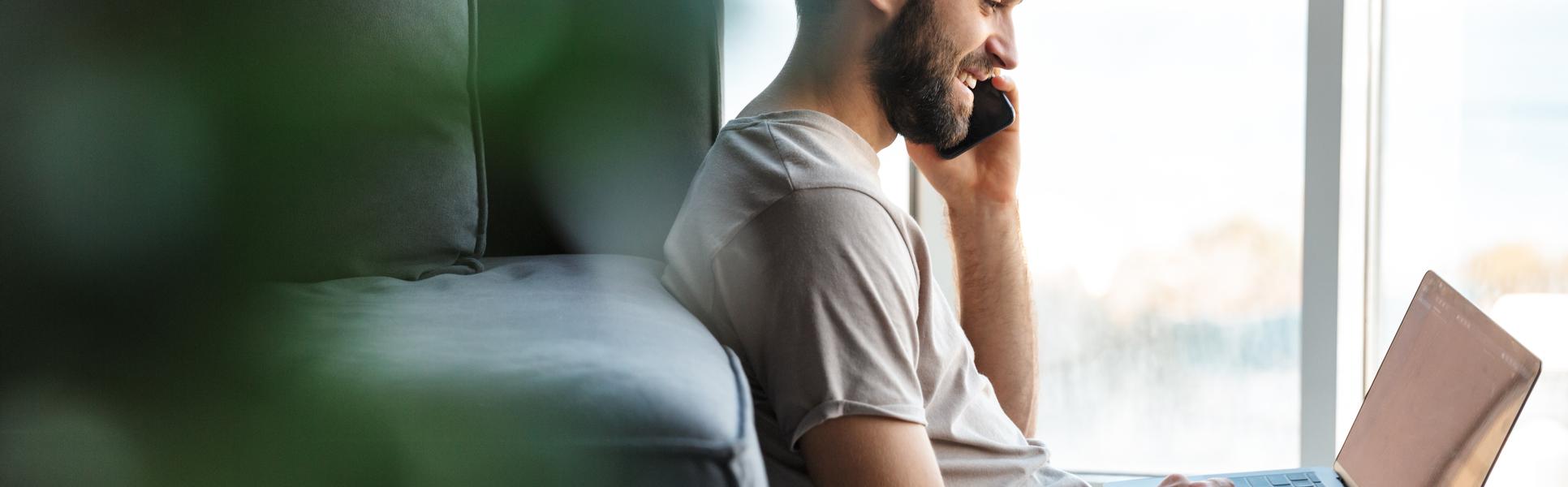 Young man with mobile and computer